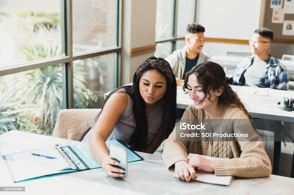 Un groupe diversifié de jeunes entrepreneurs dans un pays en développement, travaillant ensemble dans un espace de bureau moderne. Ils brainstorment autour d'une table avec des ordinateurs portables, des carnets et un tableau blanc, illustrant l'innovation, la collaboration et la transformation économique.