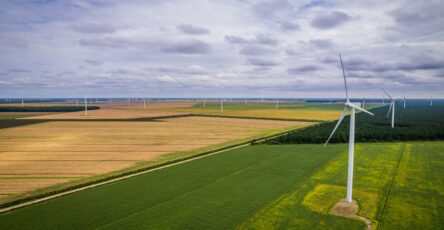 Image représentant des panneaux solaires et des éoliennes dans un paysage rural, symbolisant l'adoption des énergies renouvelables dans les pays en développement pour combler le déficit énergétique et réduire les émissions de gaz à effet de serre.